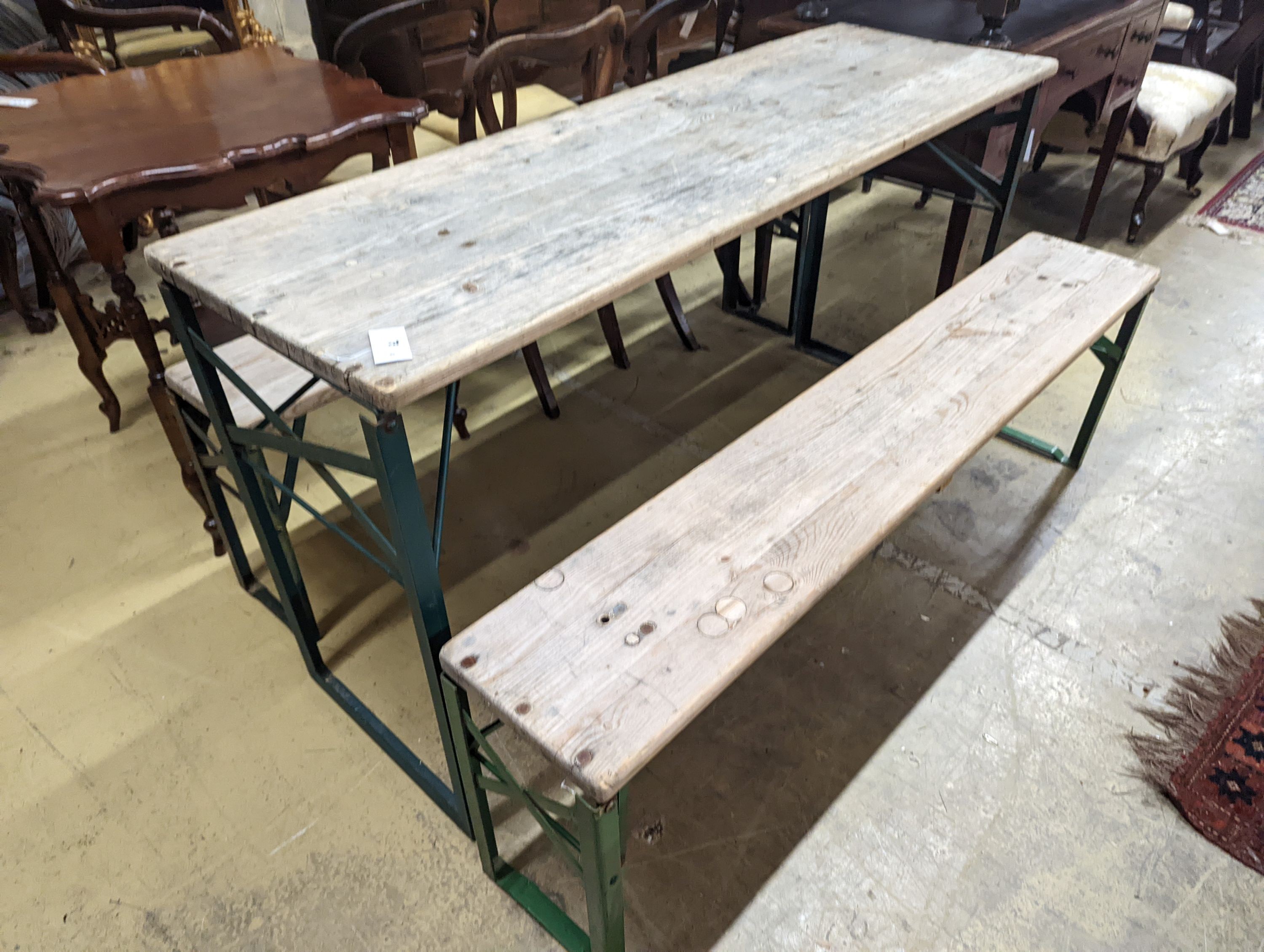 A rectangular pine and painted wrought iron folding garden trestle table, length 150cm, depth 50cm, height 78cm and a pair of matching bench seats